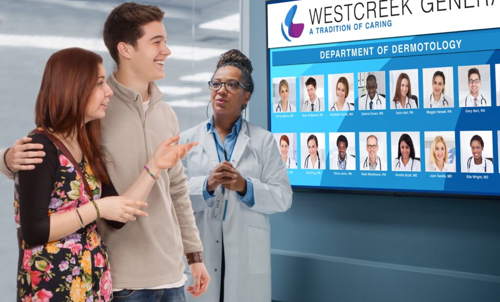 Two hospital visitors reviewing the hospital's provider directory on a LoopScreen digital display.